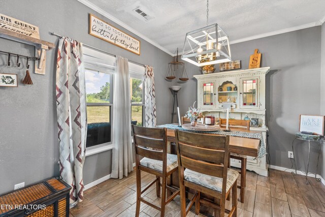 1842 Chapel Rd, Sevierville, TN 37876 - dining space featuring light wood-style floors, an inviting chandelier, ornamental molding, visible vents, and baseboards