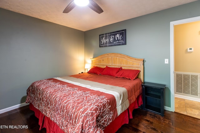 bedroom with visible vents, ceiling fan, hardwood / wood-style floors, and baseboards