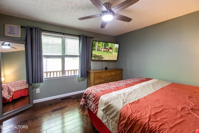bedroom with dark wood-style flooring, baseboards, visible vents, a ceiling fan, and a textured ceiling