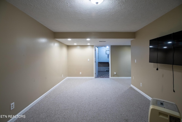 finished basement featuring recessed lighting, a textured ceiling, carpet floors, and baseboards
