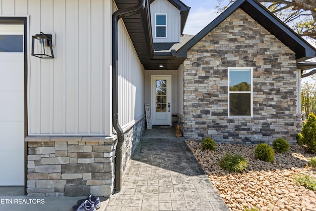doorway to property with stone siding and board and batten siding