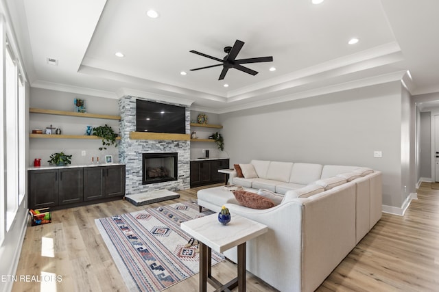 living room featuring recessed lighting, a raised ceiling, light wood-style floors, and ceiling fan