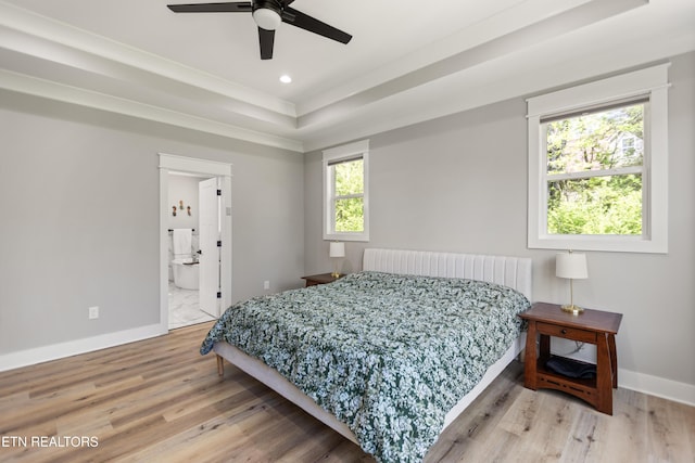 bedroom with a raised ceiling, baseboards, wood finished floors, and recessed lighting