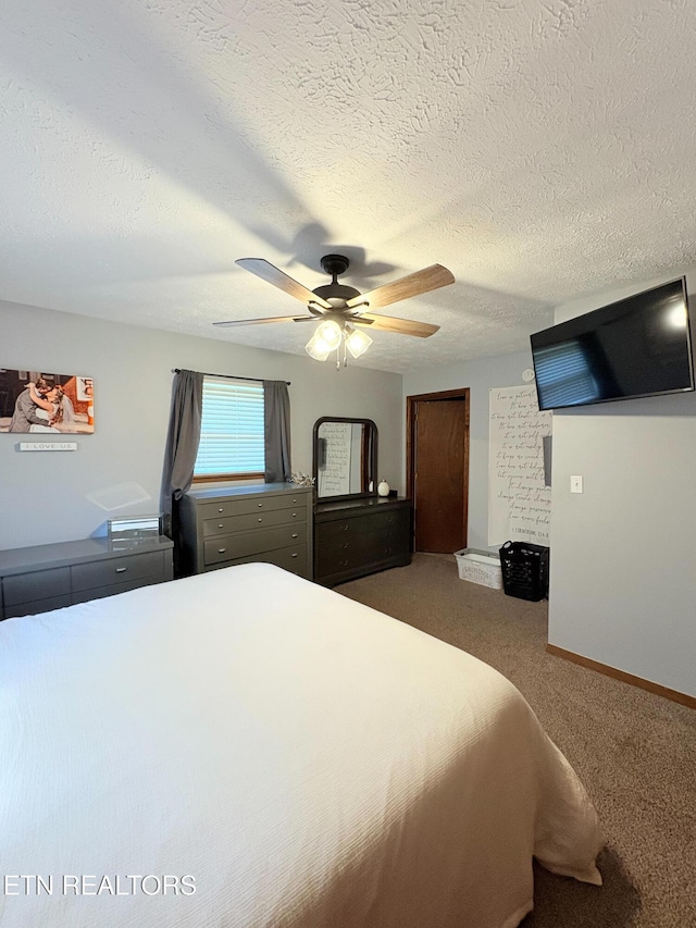 carpeted bedroom featuring baseboards, a ceiling fan, and a textured ceiling