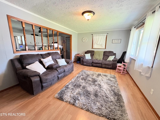 living room with baseboards, ornamental molding, wood finished floors, and a textured ceiling