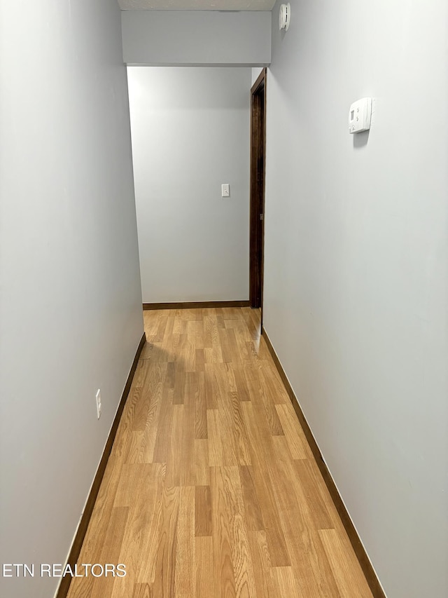 hall featuring baseboards and light wood-style flooring