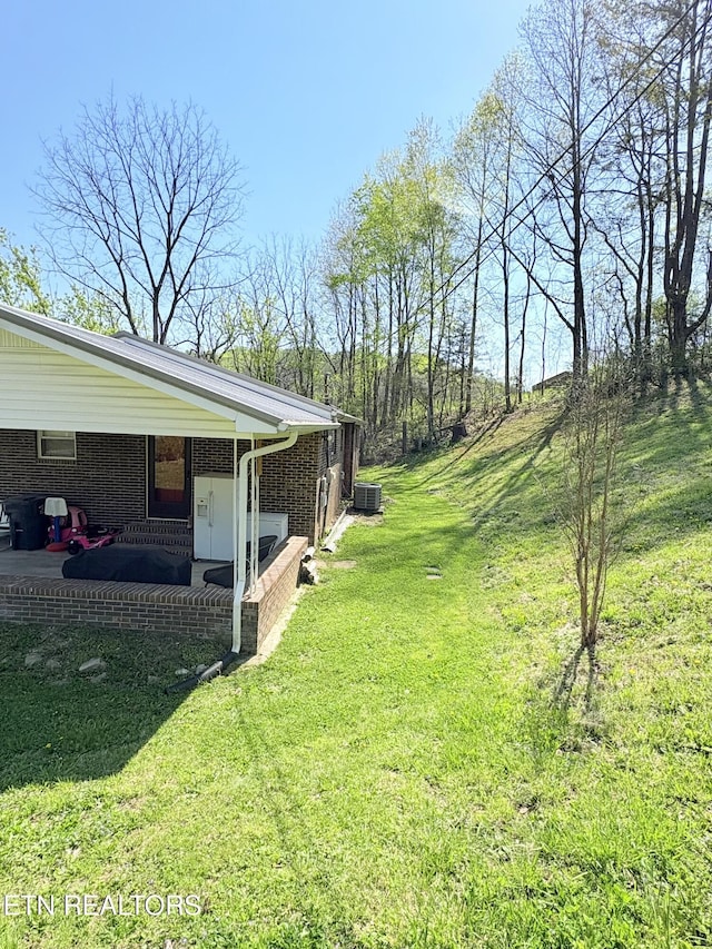 view of yard featuring central air condition unit and a patio