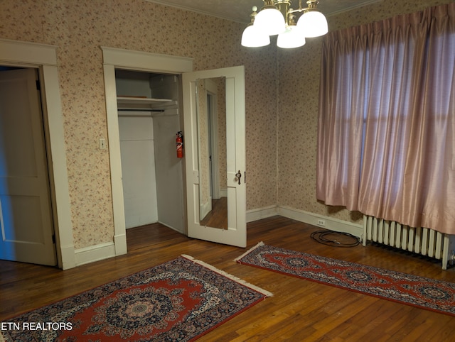 515 N 25th St, Middlesboro, KY 40965 - bedroom featuring radiator heating unit, an inviting chandelier, wood finished floors, and wallpapered walls