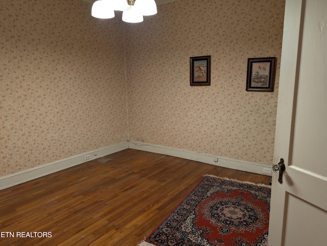 515 N 25th St, Middlesboro, KY 40965 - spare room featuring baseboards, wallpapered walls, and dark wood-style floors