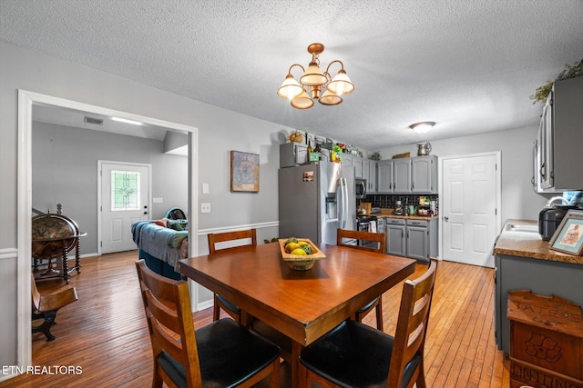 12903 Georgetown Village Ln, Georgetown, TN 37336 - dining room featuring light wood-style flooring, a chandelier, and a textured ceiling