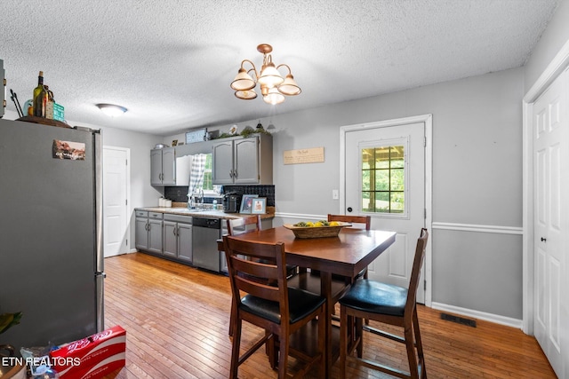 12903 Georgetown Village Ln, Georgetown, TN 37336 - dining room with light wood-type flooring, a textured ceiling, and a chandelier