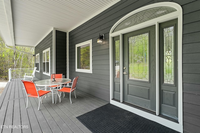 doorway to property with outdoor dining area and covered porch