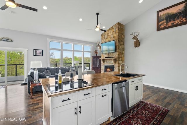 kitchen with dishwasher, a ceiling fan, open floor plan, and a sink