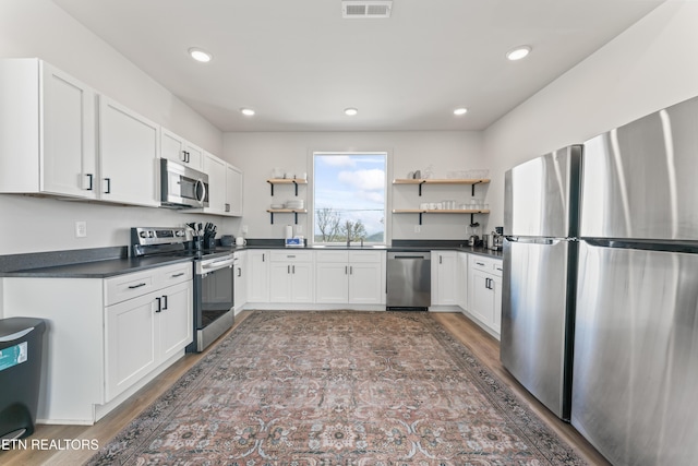 896 Chalet Village Blvd, Gatlinburg, TN 37738 - kitchen with stainless steel appliances, white cabinets, open shelves, and dark countertops