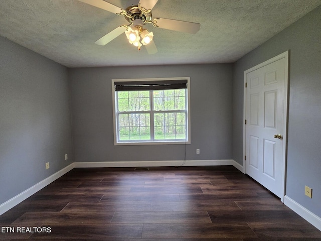 unfurnished room with a ceiling fan, baseboards, dark wood-style flooring, and a textured ceiling