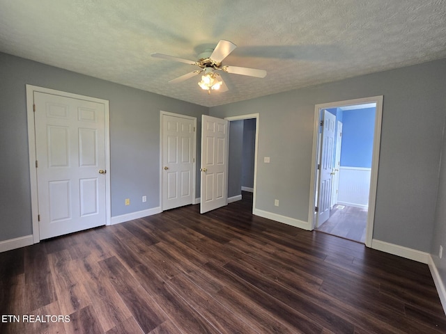 unfurnished bedroom featuring dark wood finished floors, baseboards, and a textured ceiling