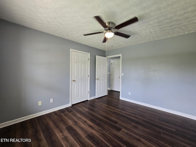 unfurnished bedroom featuring dark wood finished floors, baseboards, a ceiling fan, and a textured ceiling