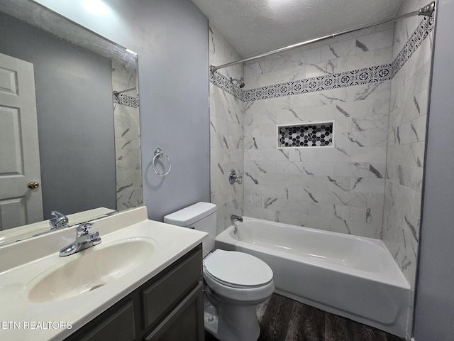 full bath featuring wood finished floors, a textured ceiling, shower / bathing tub combination, vanity, and toilet