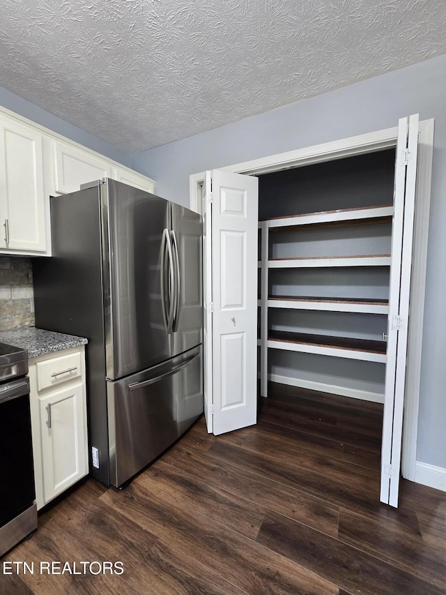 kitchen with dark wood-style floors, open shelves, a textured ceiling, appliances with stainless steel finishes, and white cabinetry