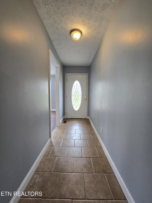 entryway with baseboards and a textured ceiling