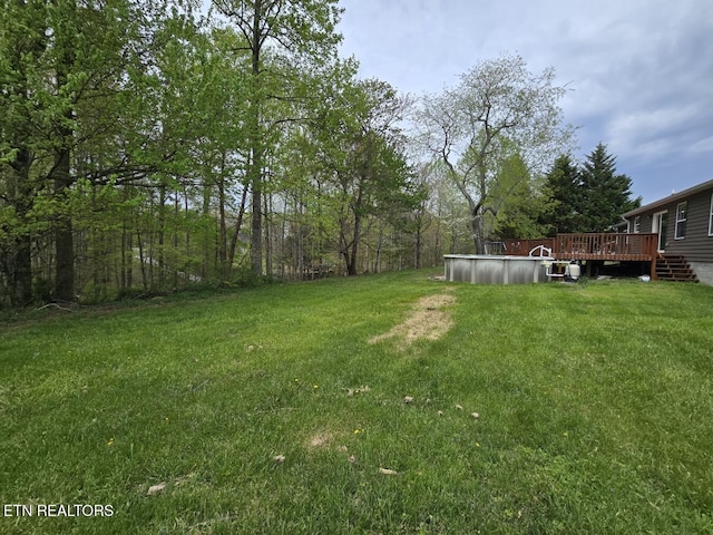view of yard featuring a wooden deck and an outdoor pool