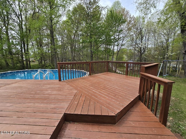 wooden terrace with an outdoor pool