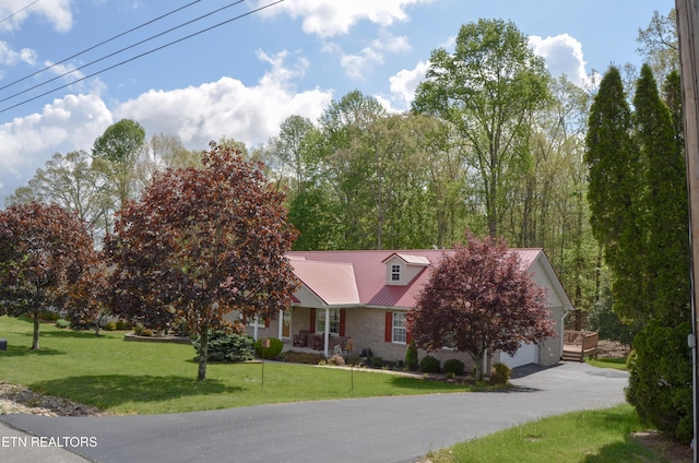 76 Sundrop Ln, Crossville, TN 38571 - view of front of home featuring a garage, a front yard, a metal roof, and driveway