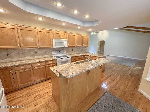 76 Sundrop Ln, Crossville, TN 38571 - kitchen with white appliances, backsplash, light wood finished floors, a breakfast bar, and arched walkways