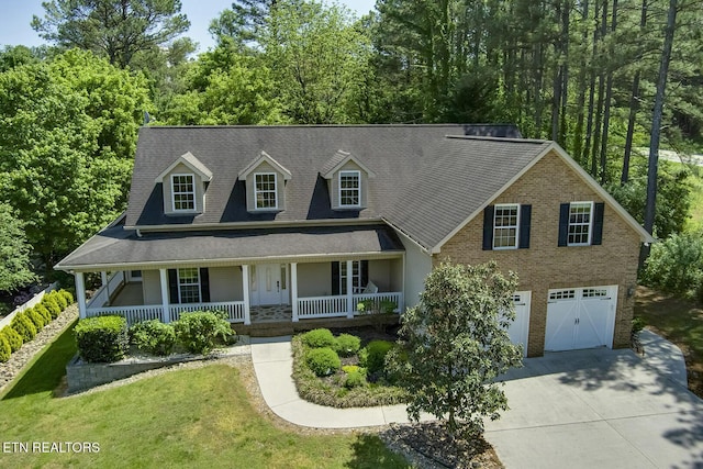 100 Coyatee Cir, Loudon, TN 37774 - view of front of house featuring driveway, brick siding, a garage, a porch, and a front lawn