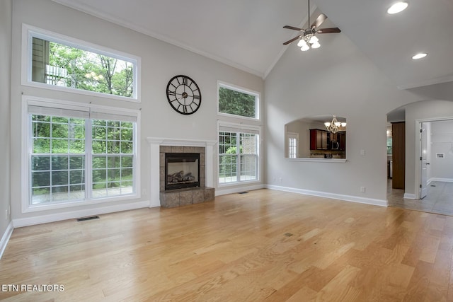 100 Coyatee Cir, Loudon, TN 37774 - unfurnished living room featuring ceiling fan with notable chandelier, high vaulted ceiling, visible vents, crown molding, and baseboards