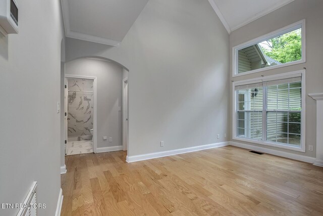 100 Coyatee Cir, Loudon, TN 37774 - unfurnished room with lofted ceiling, light wood-type flooring, visible vents, crown molding, and arched walkways