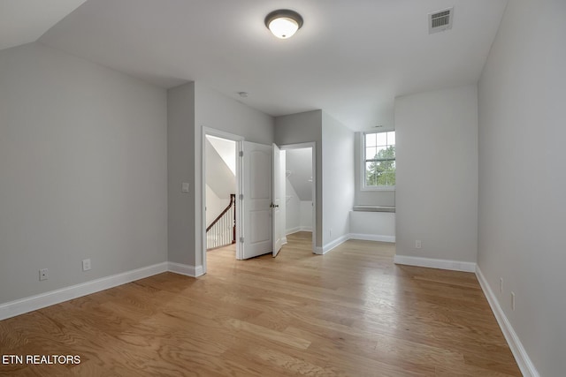 100 Coyatee Cir, Loudon, TN 37774 - unfurnished bedroom with baseboards, light wood-style floors, visible vents, and a walk in closet