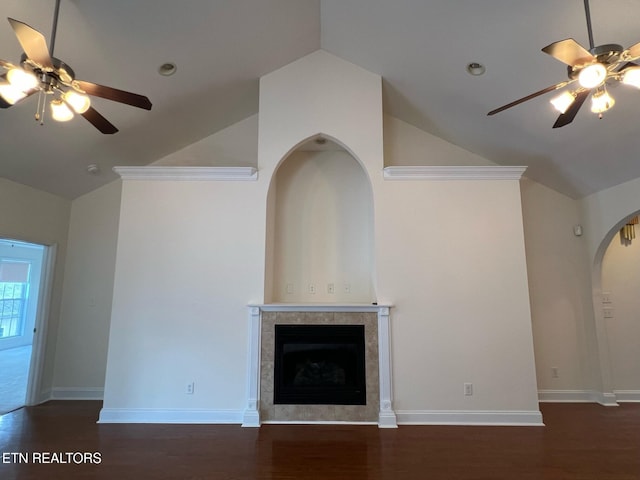 unfurnished living room with a ceiling fan, high vaulted ceiling, a tiled fireplace, and wood finished floors