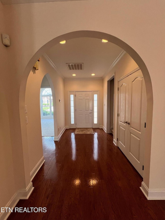 entryway with baseboards, ornamental molding, dark wood-style floors, and visible vents