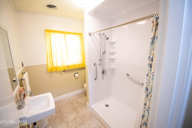bathroom with a shower stall, a sink, baseboards, toilet, and visible vents