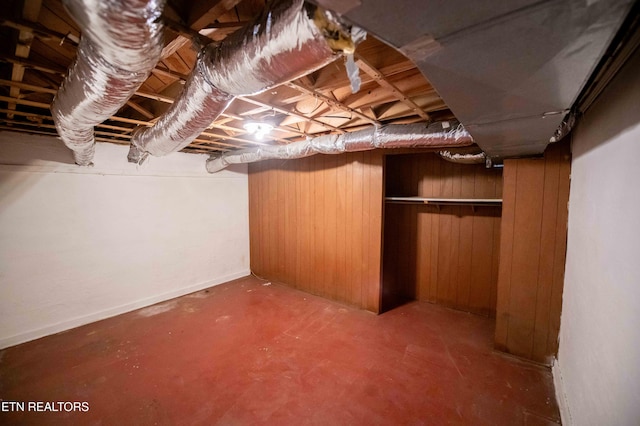 unfinished basement featuring wood walls