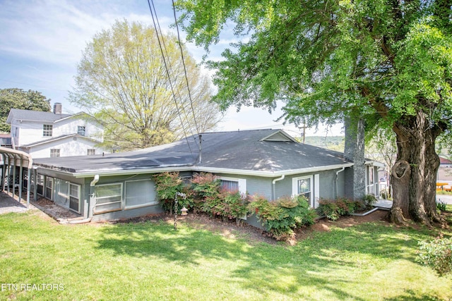 back of house featuring a sunroom and a yard