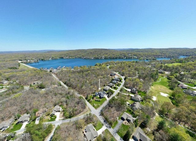 birds eye view of property featuring a forest view, a water view, and a residential view
