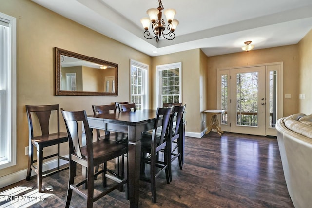 dining room with baseboards, a chandelier, dark wood-type flooring, and plenty of natural light