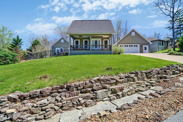 view of front of house featuring driveway, covered porch, fence, a ceiling fan, and a front yard