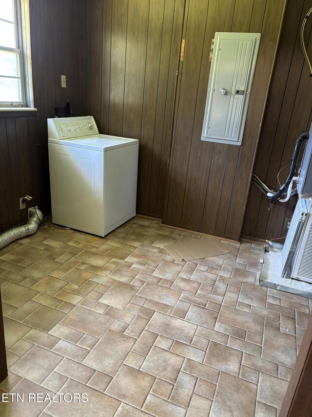 washroom with wooden walls, brick patterned floor, laundry area, and washer / clothes dryer