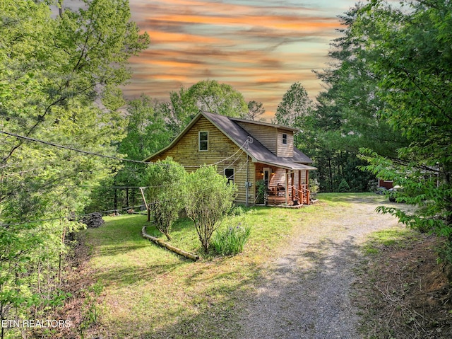 exterior space featuring a lawn and gravel driveway