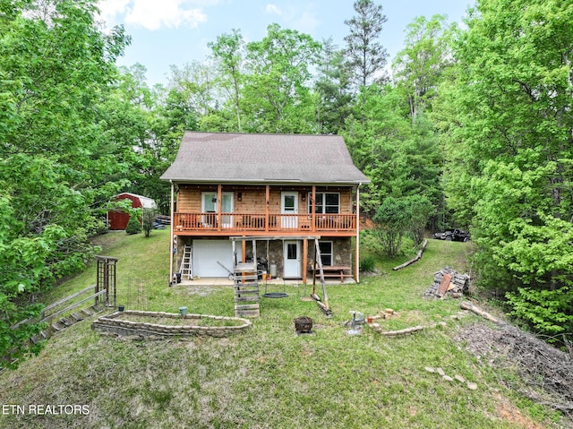 view of front facade featuring a garage, a wooden deck, driveway, and a front yard