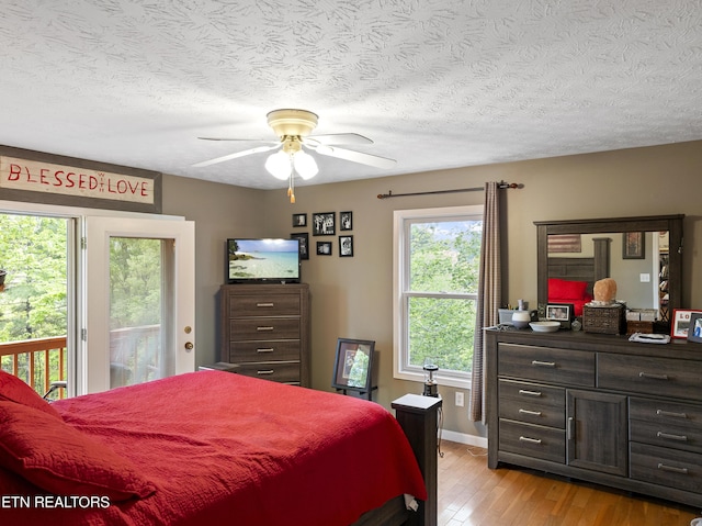 bedroom featuring access to exterior, baseboards, a textured ceiling, a ceiling fan, and light wood finished floors
