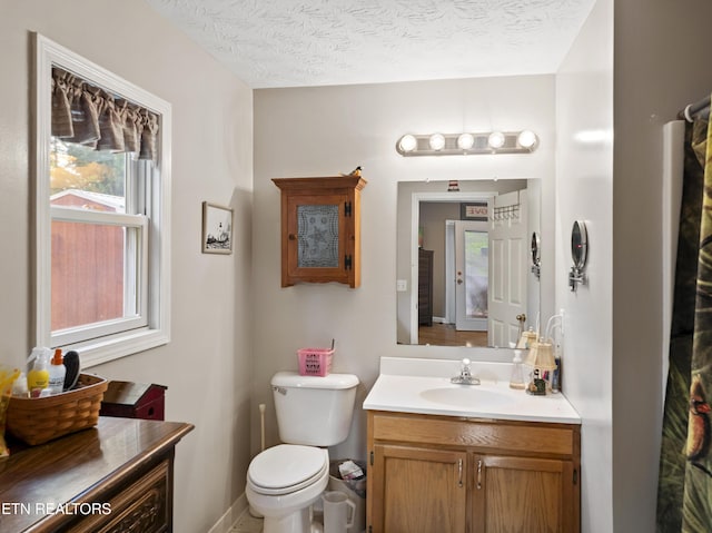 bathroom featuring vanity, a textured ceiling, and toilet