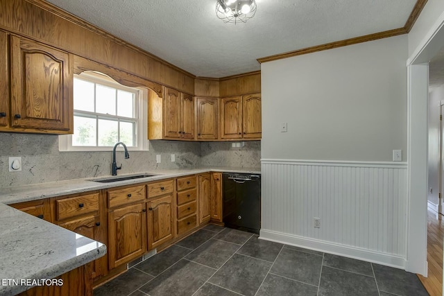 kitchen featuring brown cabinets, backsplash, dishwasher, a sink, and crown molding