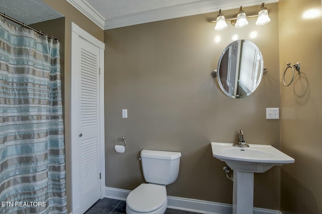 bathroom with crown molding, tile patterned floors, a closet, baseboards, and toilet
