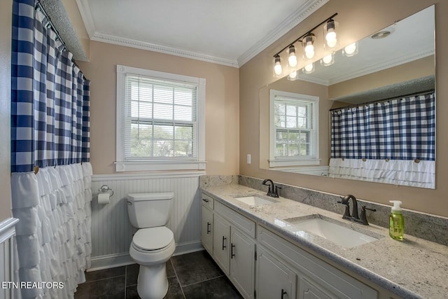 full bathroom with tile patterned floors, toilet, a wainscoted wall, and a sink