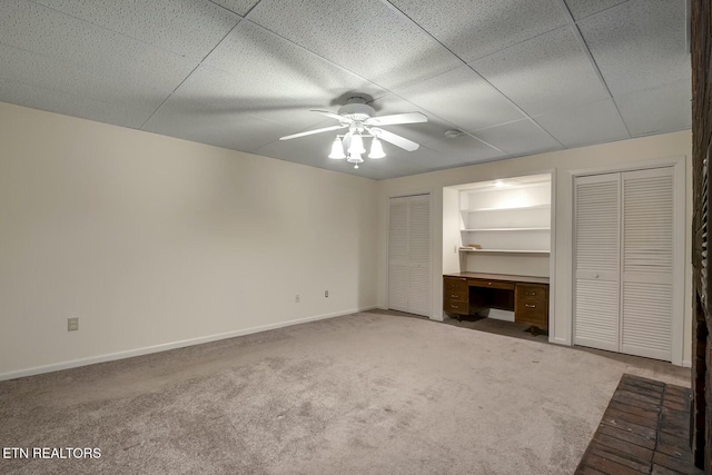 unfurnished living room featuring carpet floors, a ceiling fan, and baseboards