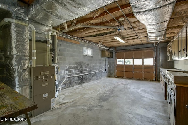 garage featuring concrete block wall and heating unit